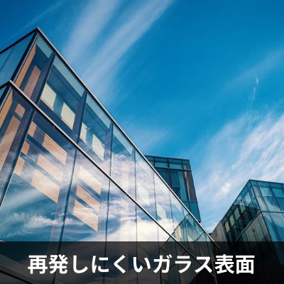 ガラス表面にコーティングを施し、水垢・ウロコの再付着を防止する仕組みを示した図。再生研磨後のガラスを長期間きれいに保つための保護コーティング効果を解説。