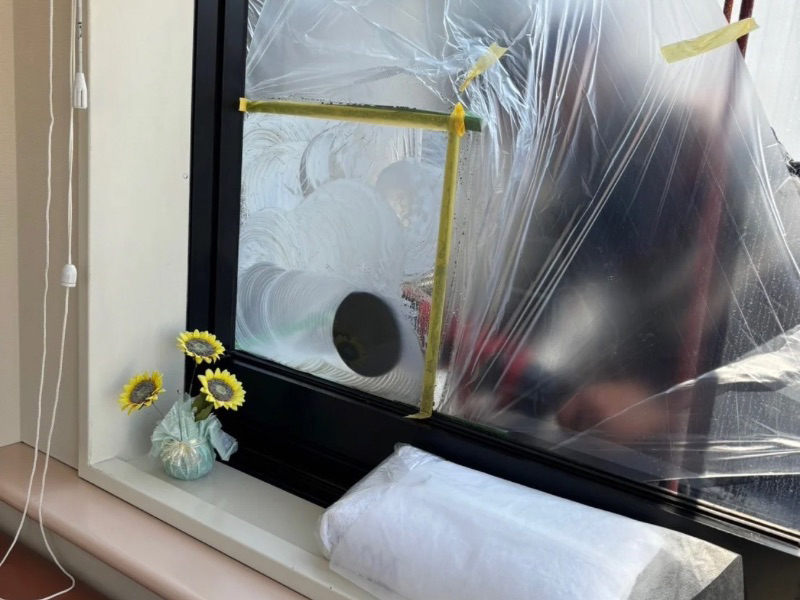 高所ロープ作業でビルの窓ガラスの水垢を除去している施工事例の様子