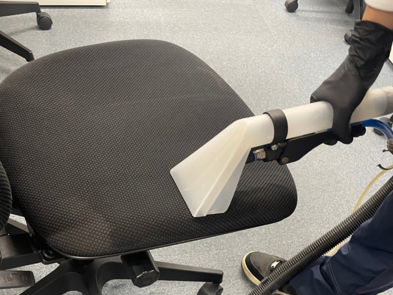 オフィスチェアのリンサー清掃で汚れを吸い取る様子。