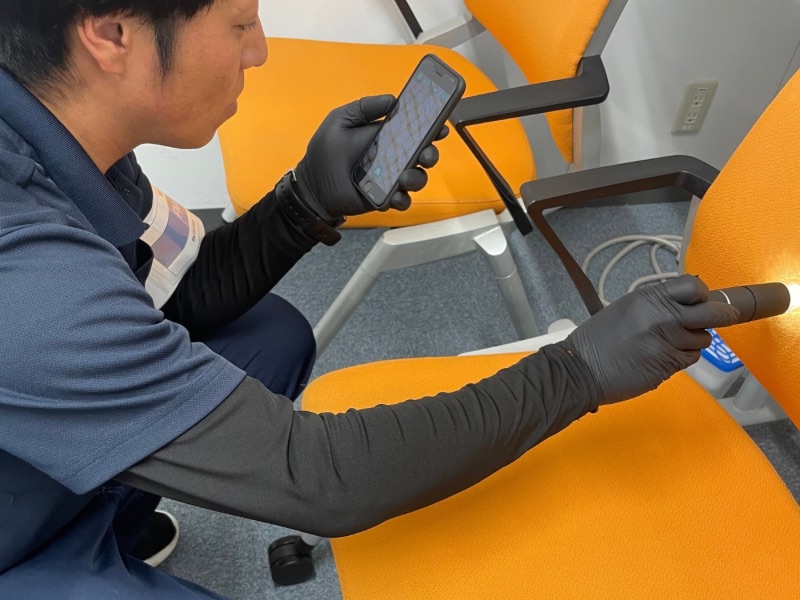 光触媒コーティング塗布後、スマートフォンで施工面を確認している様子。