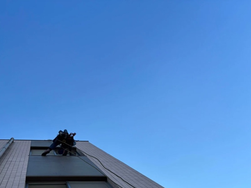 足場を使わずロープで高所窓ガラス清掃を行う専門作業員