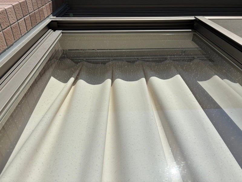 清掃前の高所窓ガラスに雨ジミや汚れが付着している状態