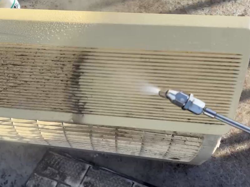 分解したエアコンを丁寧に洗浄している作業中の様子