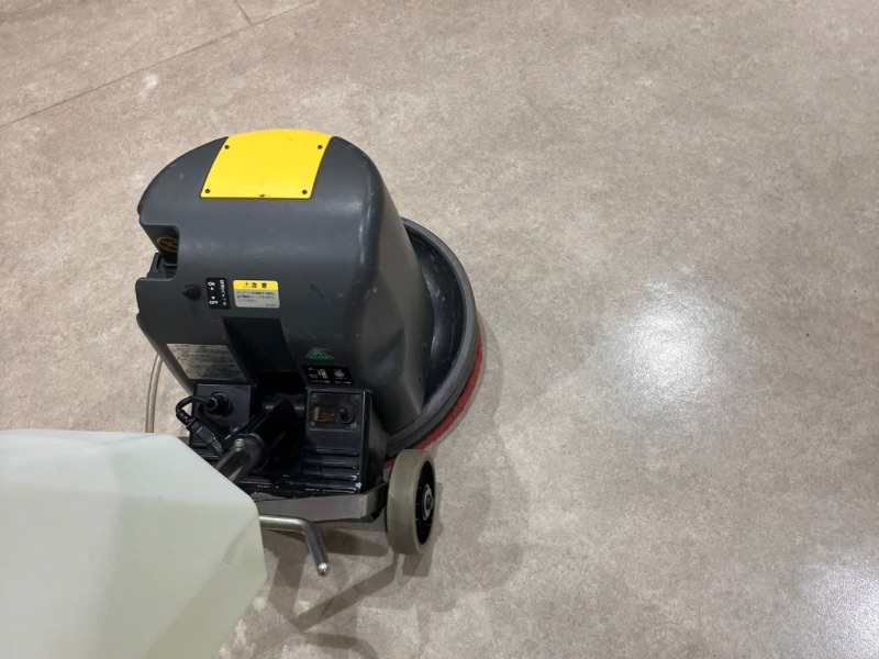 高崎市の公共施設にて、床用ポリッシャーで古い汚れを洗浄するプロの清掃員。