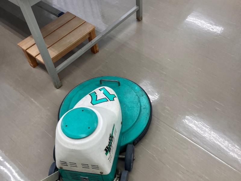 超高速バフ機（バーニッシャー）を使用して床の光沢を復元する作業風景。