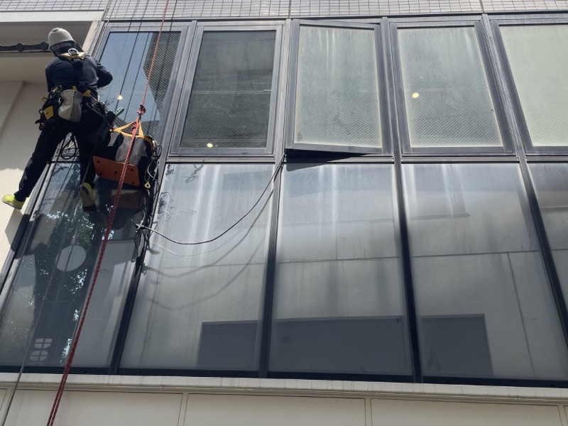 目白の2階ガラスで再生研磨作業を行う施工スタッフ