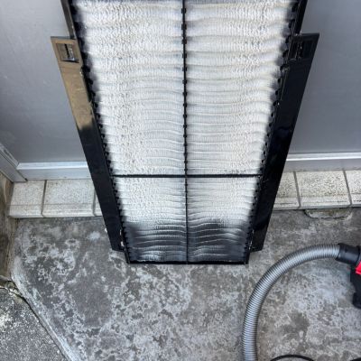 清掃前の業務用エアコンフィルター。ホコリやカビが付着し、通気が悪くなっている状態。