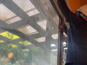 温泉成分によるウロコ汚れが付着した大浴場ガラスを再生研磨している作業風景