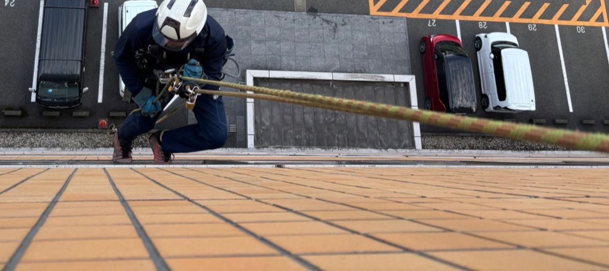 高所ロープ作業による外壁清掃のトップ画像。ビル外壁の黒ずみや汚れを安全なロープアクセスで除去し、美観を回復するサービス紹介ページ。