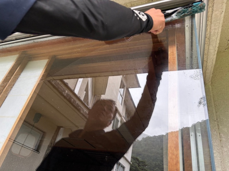 旅館の窓ガラスを専用道具で清掃している作業風景