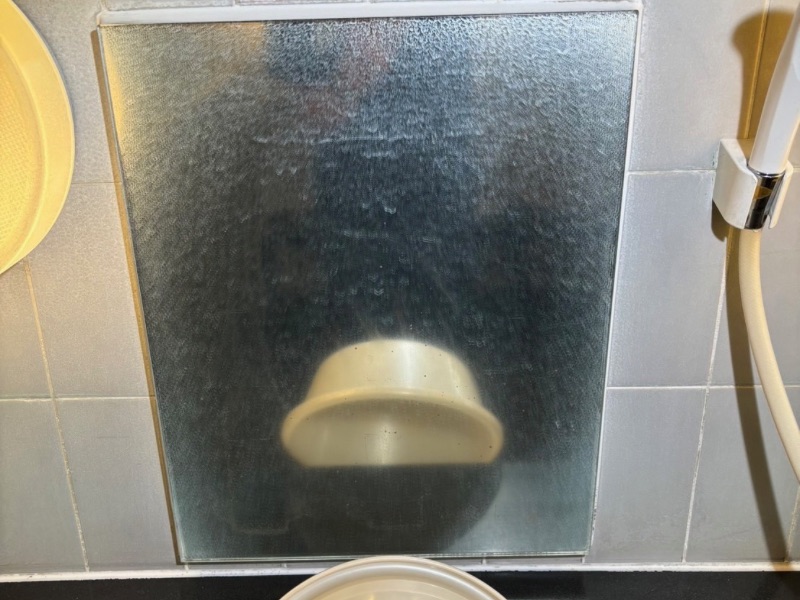 草津温泉の旅館大浴場の浴室鏡に白いウロコ汚れが広く付着している施工前の様子