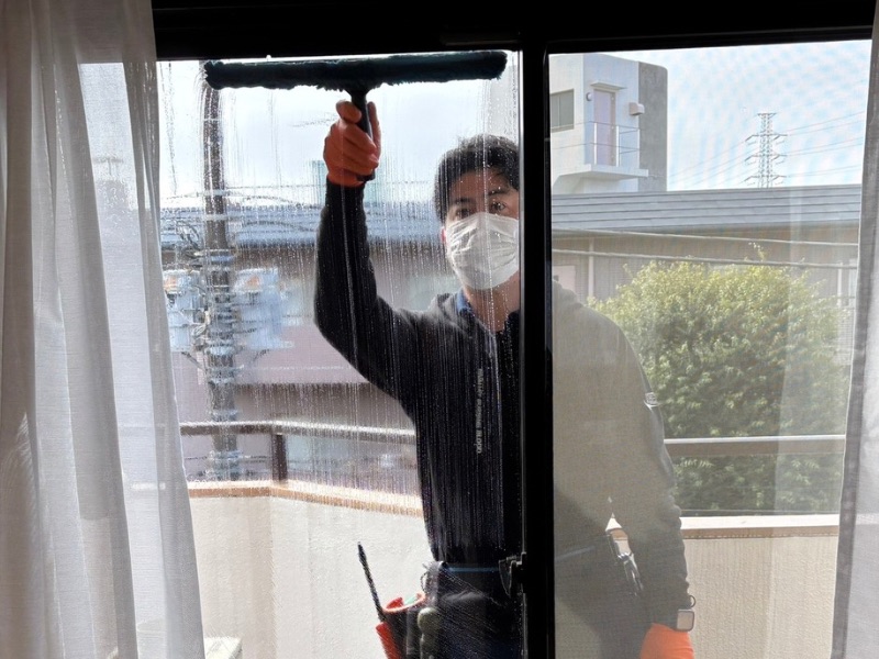 シャンパーで汚れを浮かせた後、スクイジーで一気に水を切る窓ガラス清掃の技術。