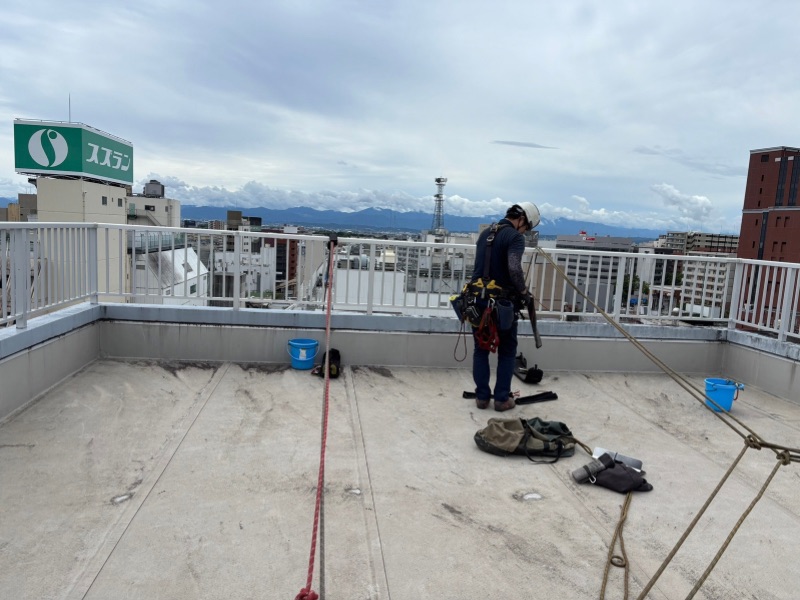 前橋市のオフィスビル屋上でロープアクセスの準備を行う様子