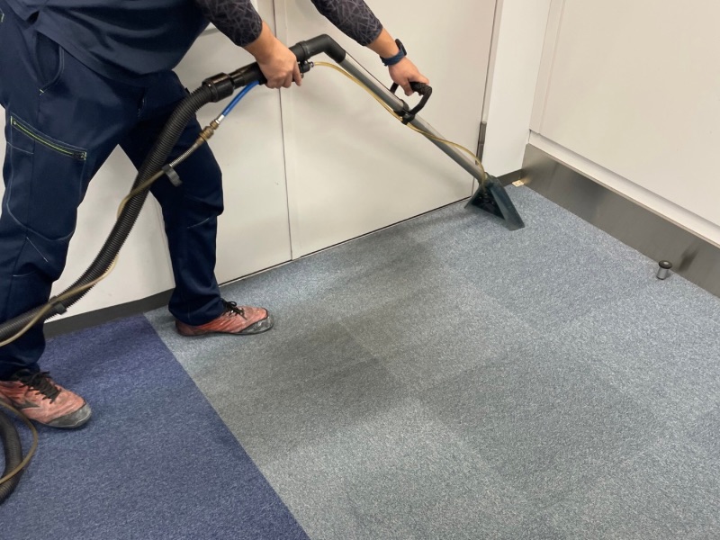 品川区オフィスのカーペットをリンサーで洗浄中。繊維の奥の汚れを吸い取る様子。