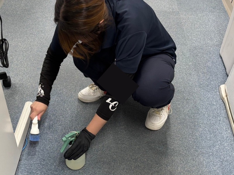 品川区オフィスカーペットのシミを手作業で除去している様子。