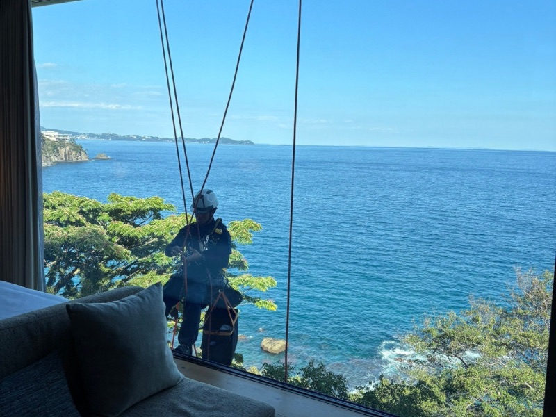 静岡県ホテルの窓ガラスに光触媒CLEANEST NFE2を塗布している作業風景。ガラス面の抗菌・防臭効果を高めるため丁寧に施工している。。