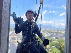ロープアクセスによる高所窓ガラス清掃作業の様子