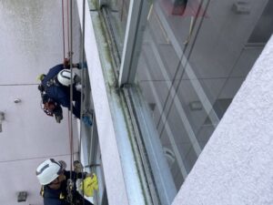 高所窓ガラス清掃を行うロープアクセス作業員