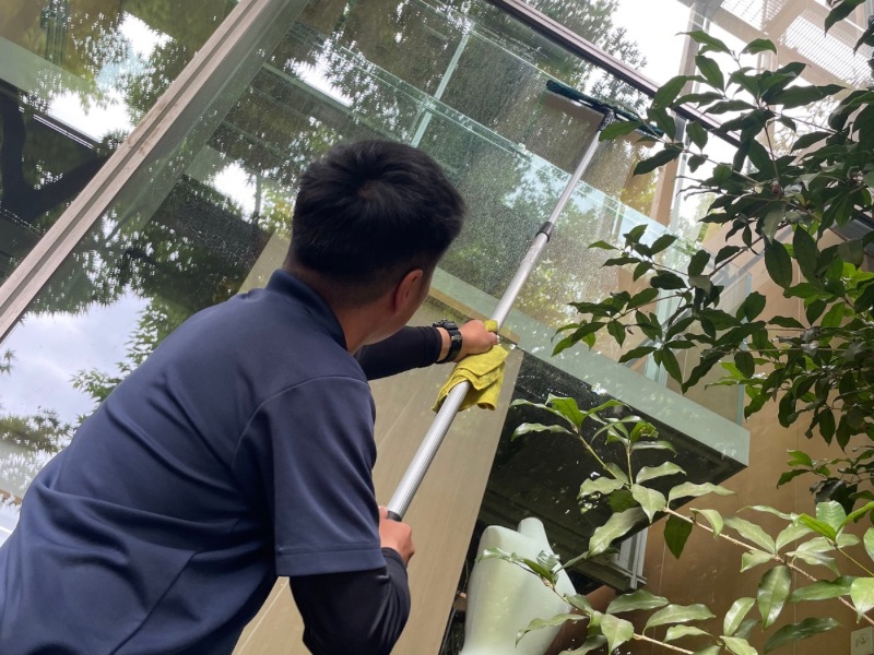 所沢市のホテルで専用ポールを使用して窓ガラスを清掃する作業